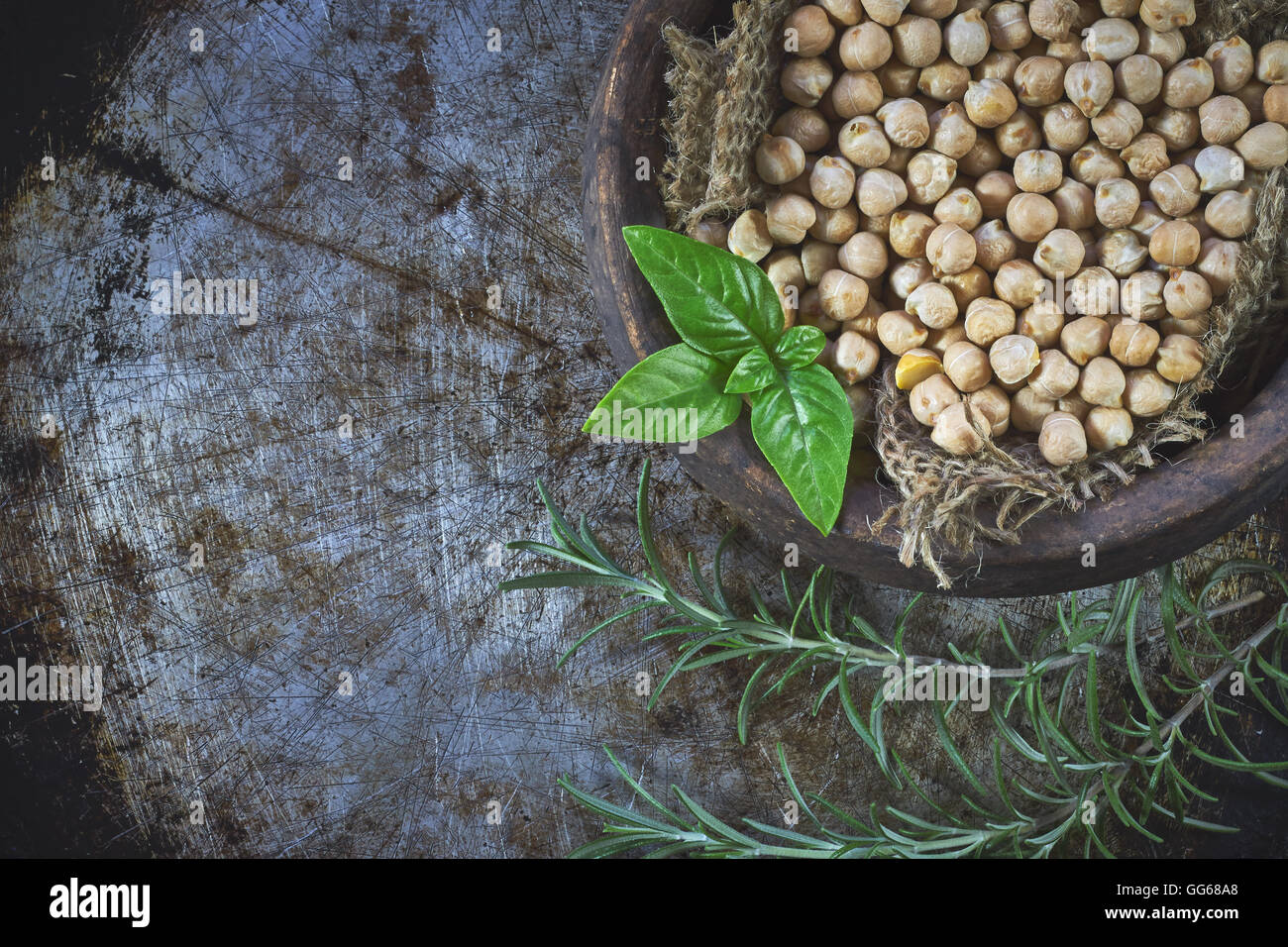 Garbanzo beans (chickpeas) with basil in clay bowl on metallic rustic background. Top view with copy space Stock Photo