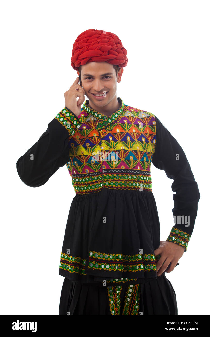 Male dandiya dancer talking on a mobile phone Stock Photo - Alamy