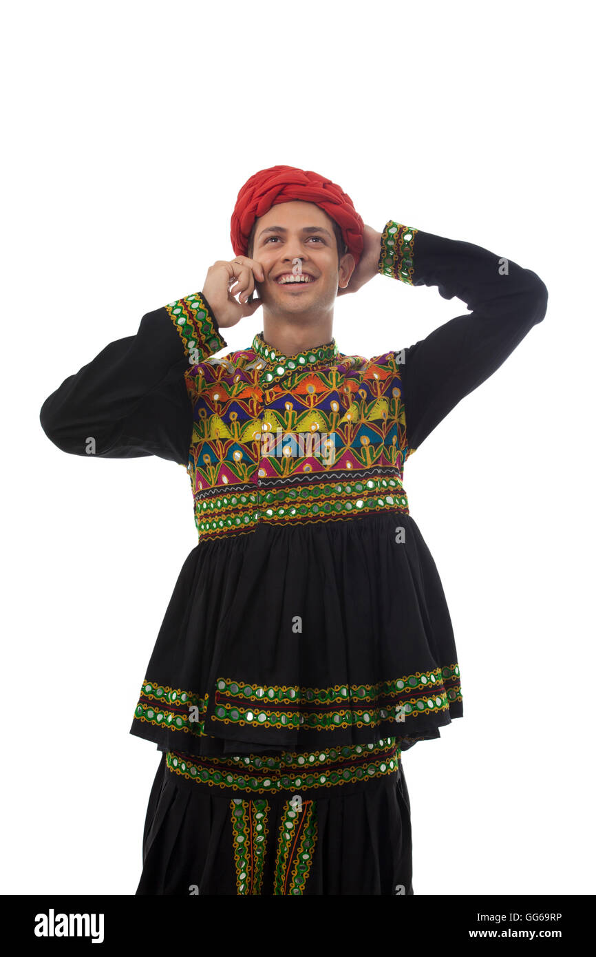 Male dandiya dancer talking on a mobile phone Stock Photo - Alamy