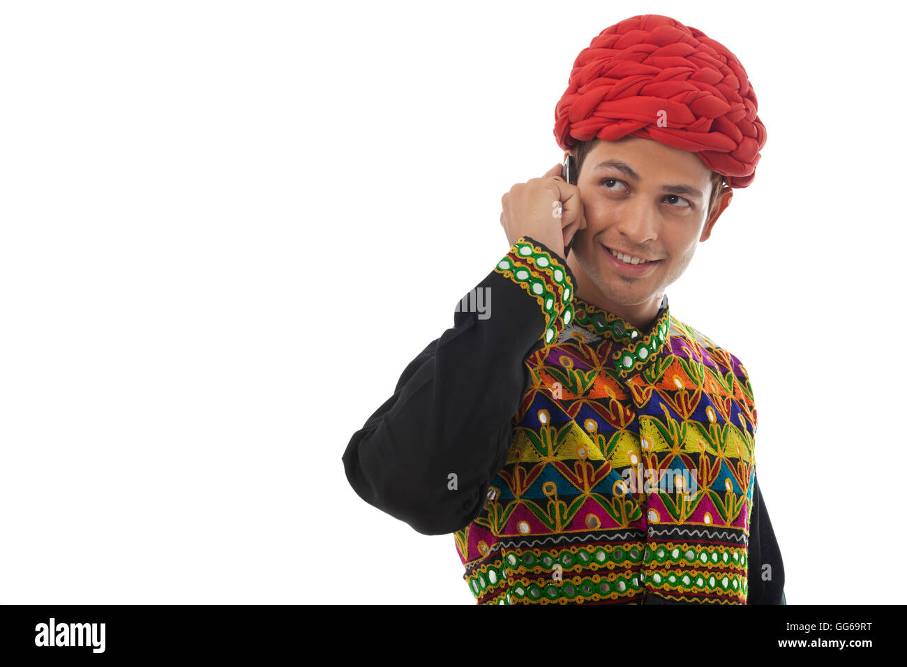 Male dandiya dancer talking on a mobile phone Stock Photo - Alamy