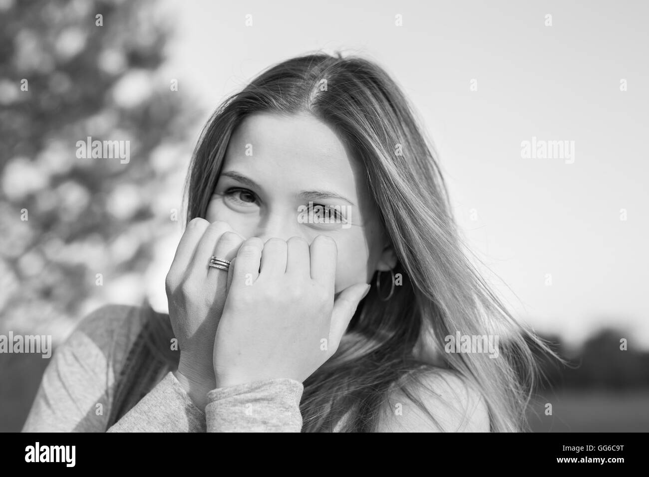 Surprised young woman with hands over her mouth outdoor Stock Photo