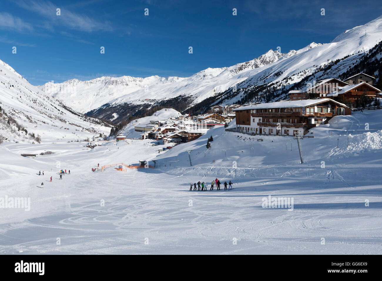 Groups of skiers enjoying the winter conditions with the village of Obergurgl and Otztal Alps beyond, Tyrol, Austria, Europe Stock Photo
