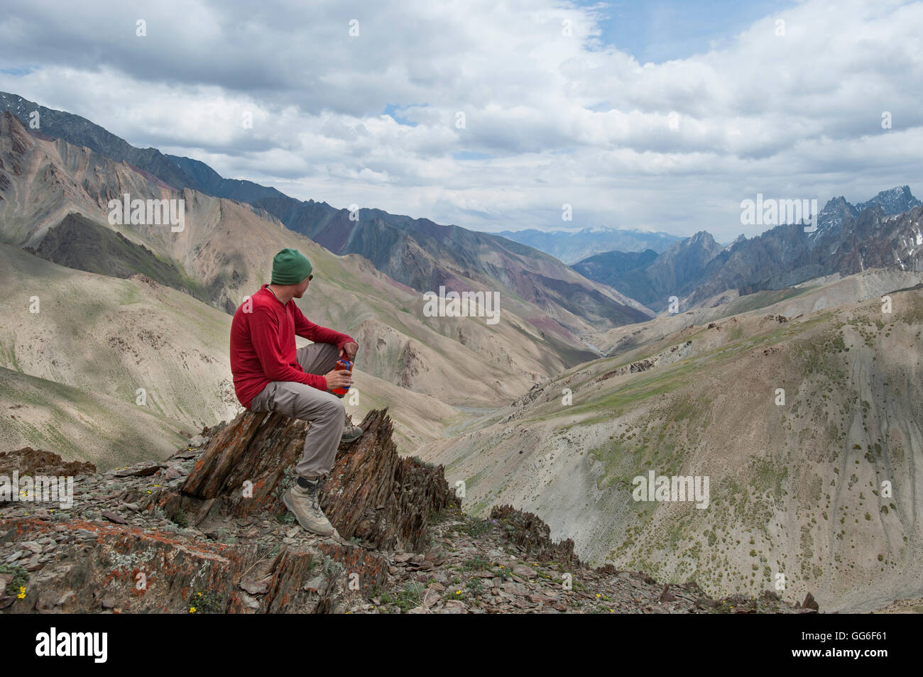 A trekker stops to admire the views from the top of the Konze La in the remote Himalayan region of Ladakh, India Stock Photo