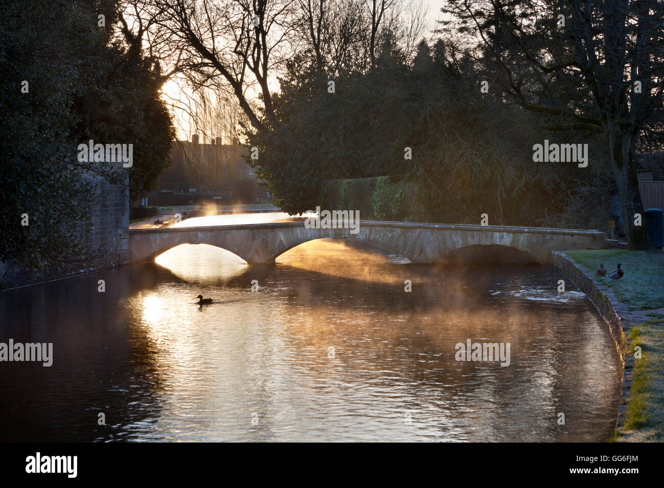 Cotswold stone bridge over River Windrush in mist, Bourton-on-the-Water, Cotswolds, Gloucestershire, England, United Kingdom Stock Photo