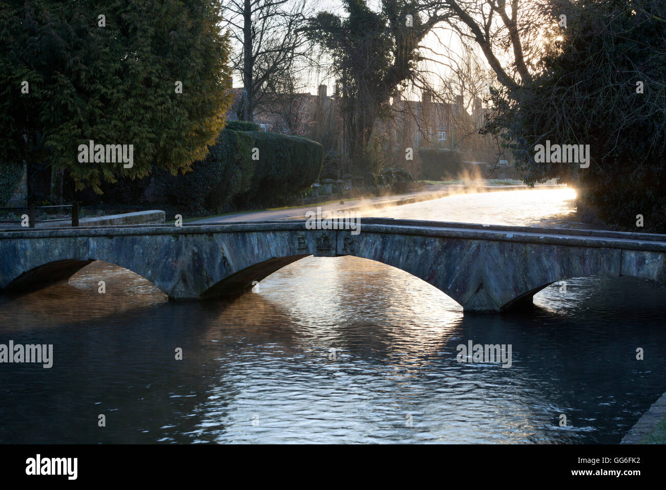 Cotswold stone bridge over River Windrush in mist, Bourton-on-the-Water, Cotswolds, Gloucestershire, England, United Kingdom Stock Photo