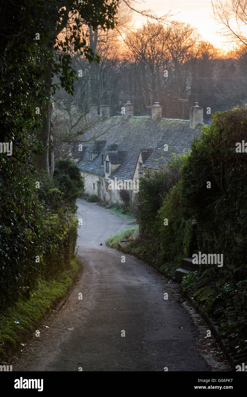 View down lane to Arlington Row Cotswold stone cottages at dawn, Bibury, Cotswolds, Gloucestershire, England, United Kingdom Stock Photo