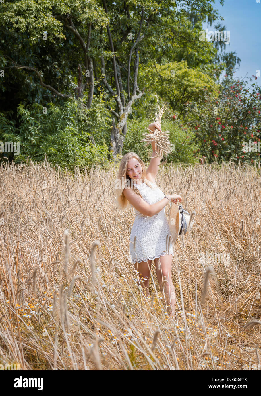 Young woman in golden wheat field Stock Photo - Alamy