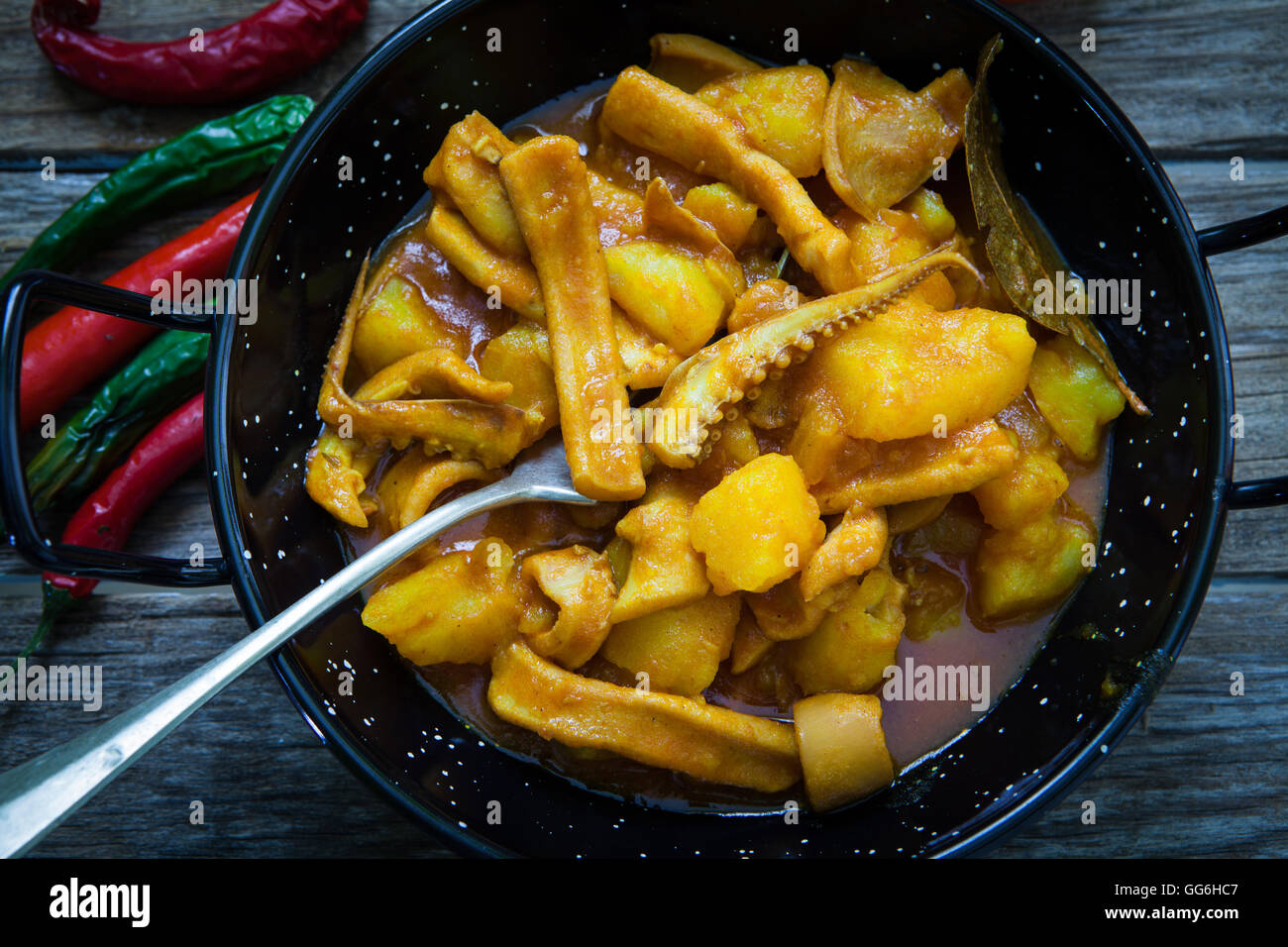 seafood plate with squid on tomato sauce with potatoes and onions Stock Photo