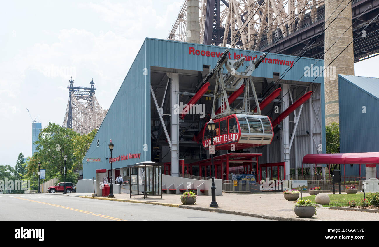 Roosevelt Island Tramway station with red tram car, and Queensboro Bridge in the background New York City. Stock Photo