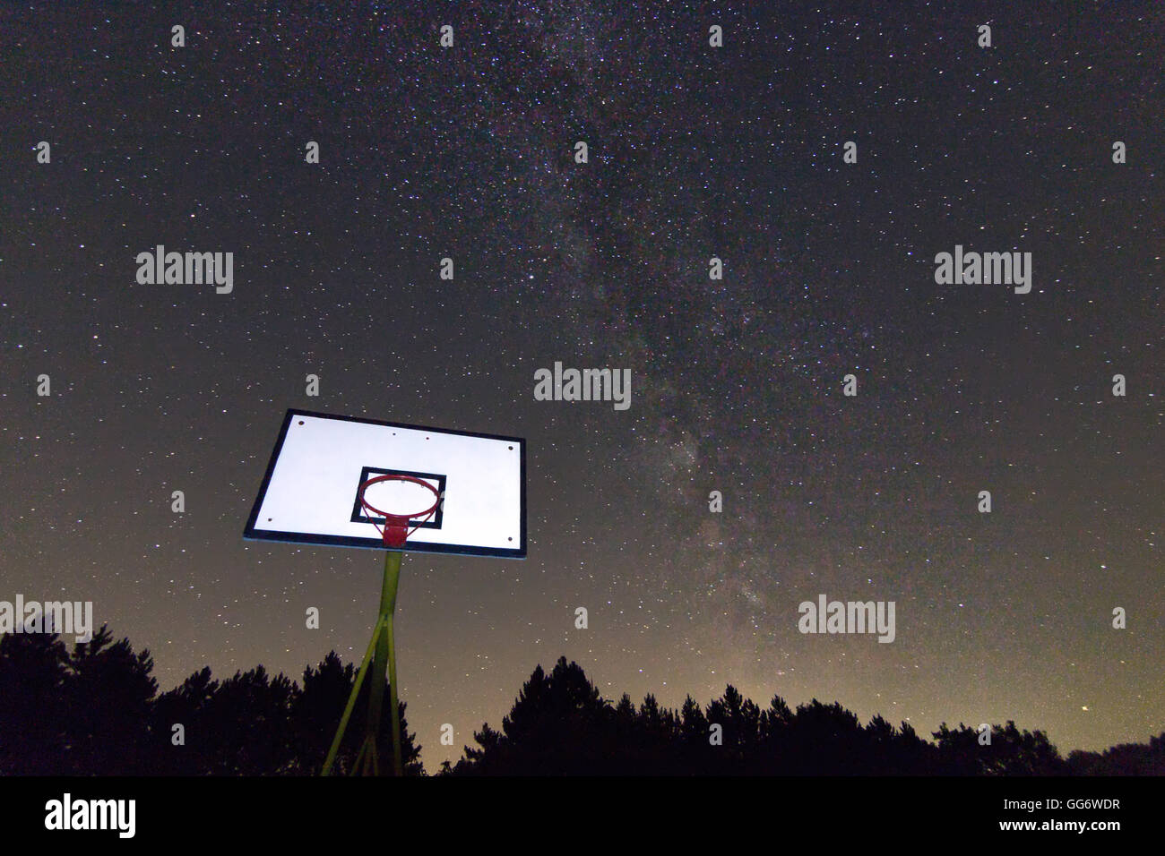 Basketball hoop and board under starry night. Milky way galaxy