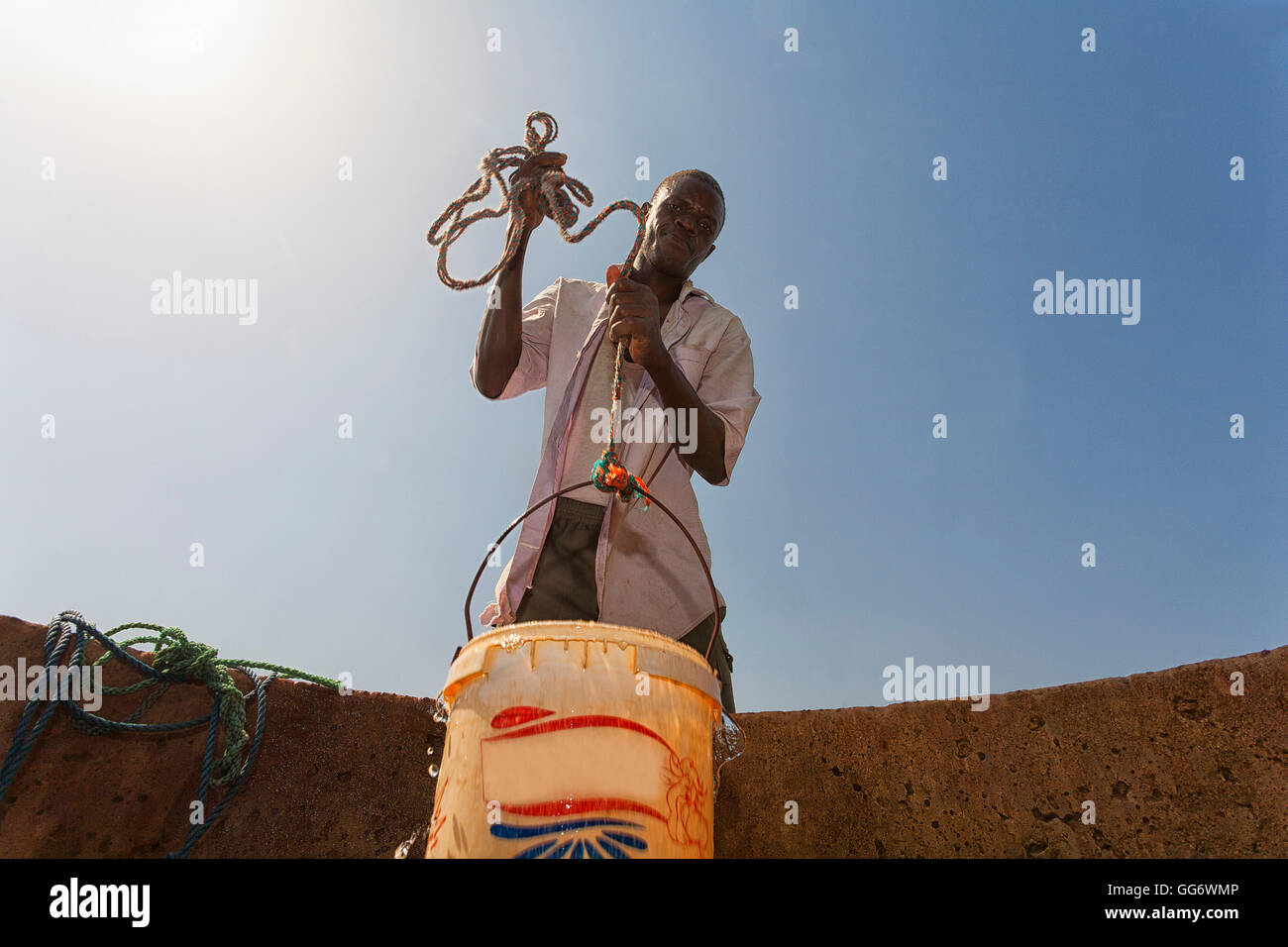 man fetching water from a well in the sahel region of the Senegal river, Senegal Stock Photo