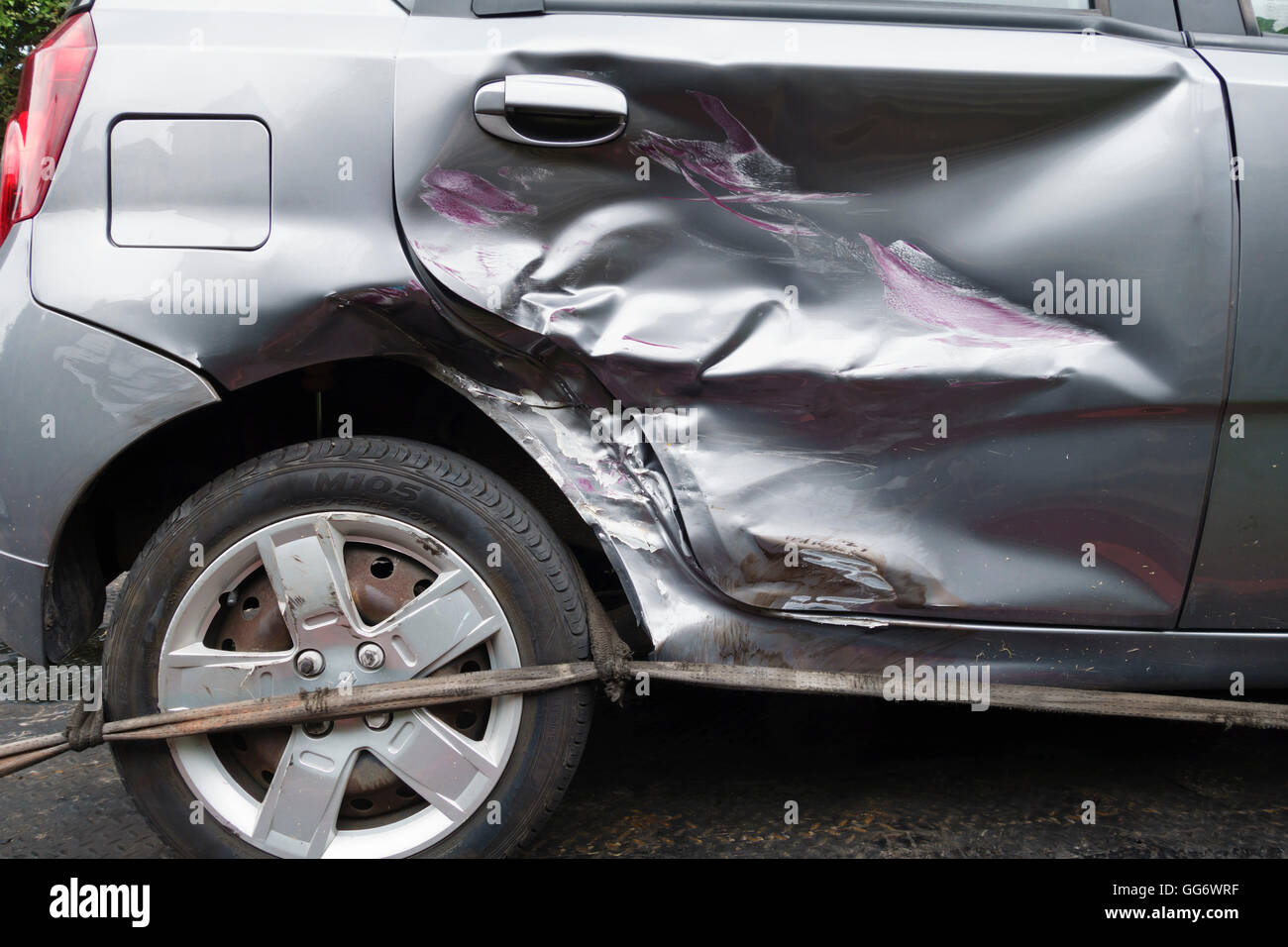 UK. A car with a badly dented rear door following a collision with another vehicle Stock Photo