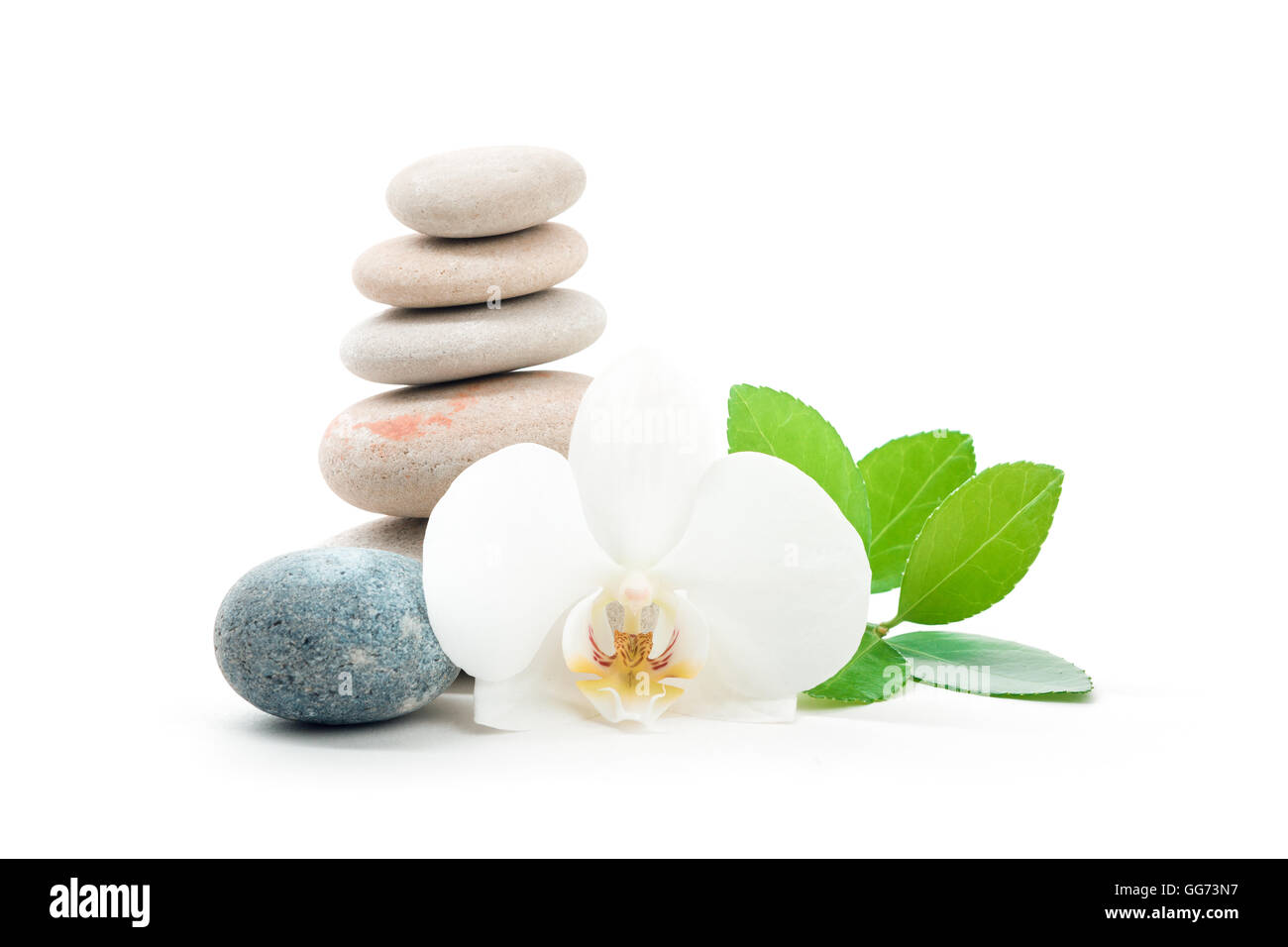 Pile of balancing pebble stones and green leaf, like ZEN stone, isolated on white background, spa welness tranquil scene concept Stock Photo