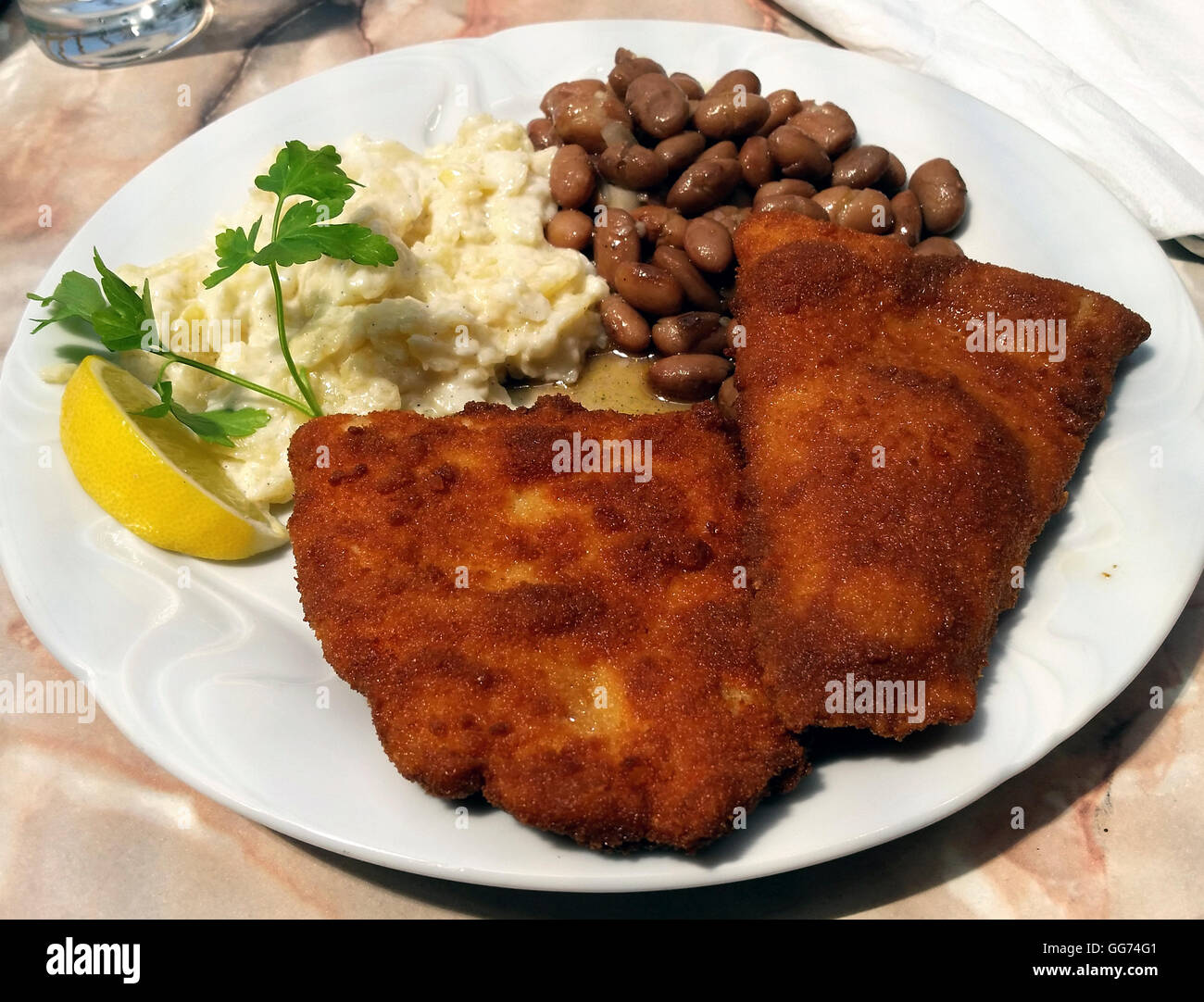Fish in breadcrumbs, potatoes and beans. Typical Slovenian lunch. fish