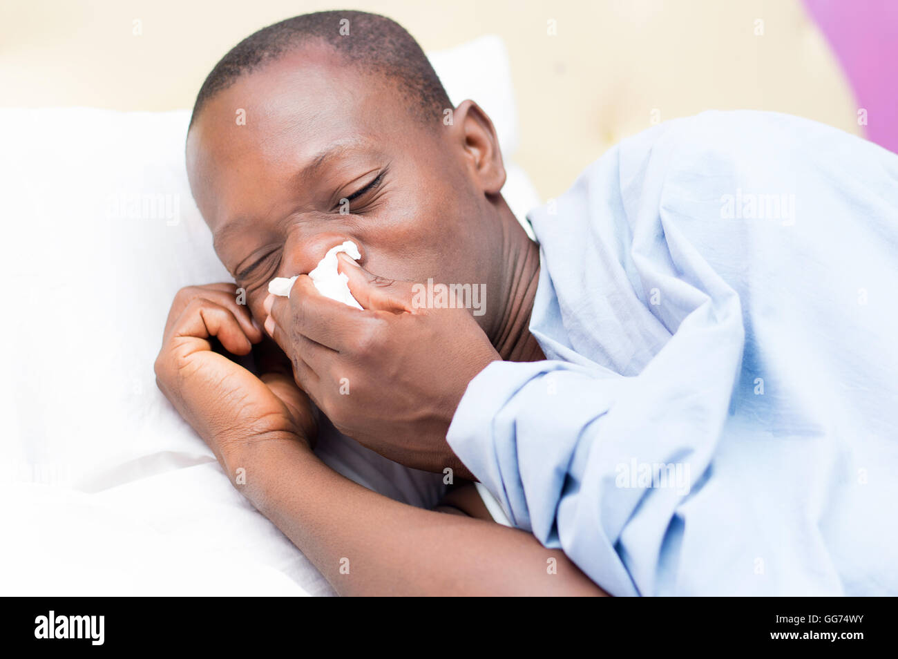 young man lying on the bed is cold and feverish Stock Photo