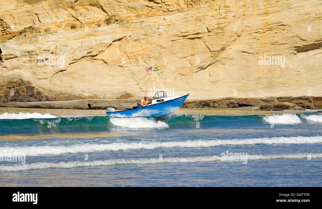 A dory boat lands on the beach at high speed in Pacific City