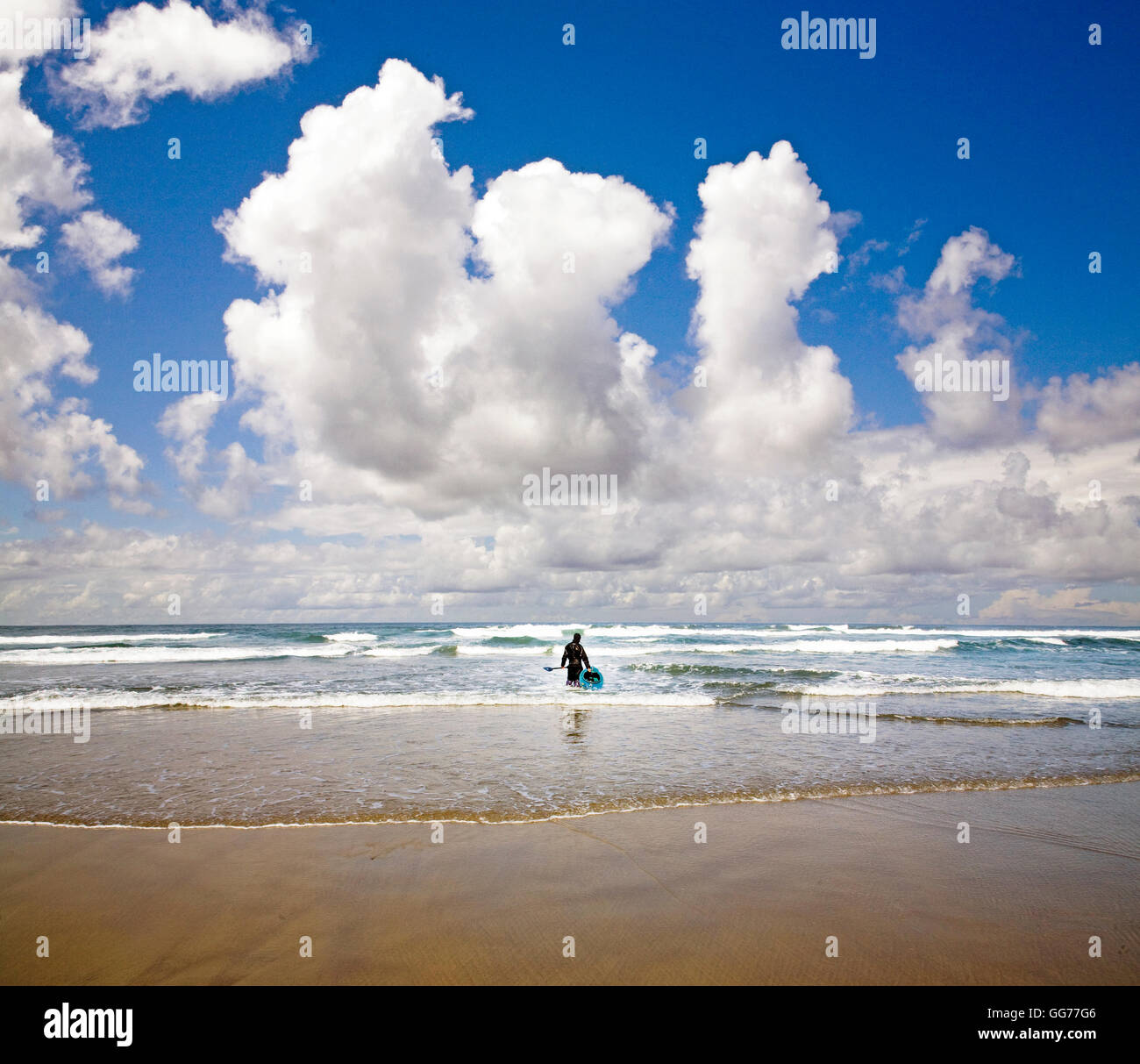 A kayaker in a small kayak prepares to launch into the Pacific Ocean