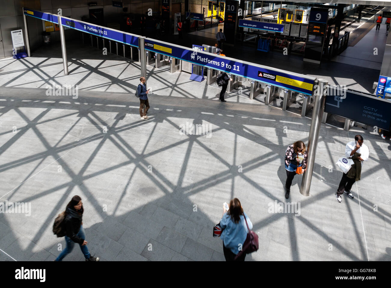 London, UK - July 5, 2016 - Travellers pass along platforms in Kings Cross train station Stock Photo