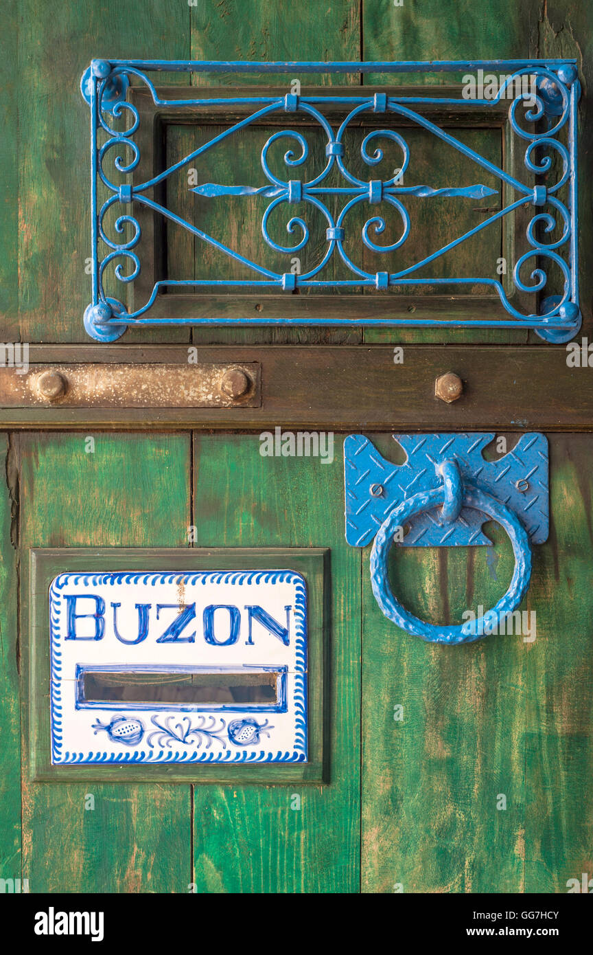 Wooden door with a slot mailbox and the word in Spanish means "box