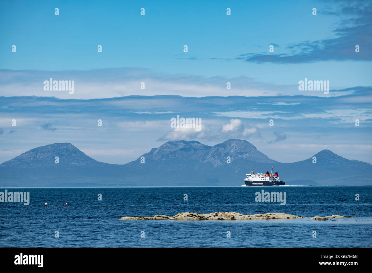 View of The Paps of Jura mountains on the Island of Jura and CalMac passenger ferry from Kintyre Peninsula in Argyll and Bute , Stock Photo