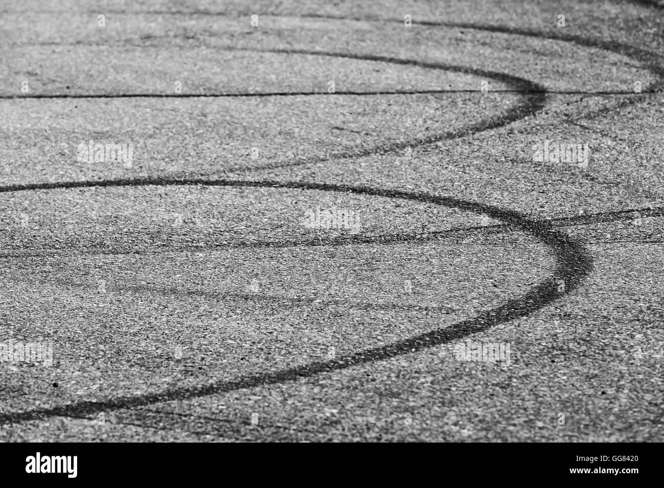Abstract transportation background, dark tire tracks on gray asphalt road Stock Photo