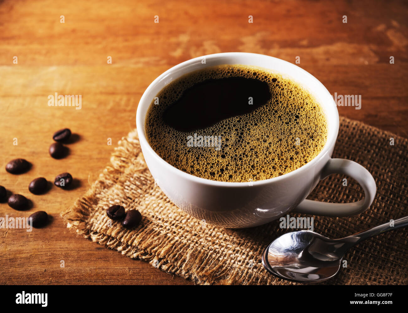 https://c8.alamy.com/comp/GG8F7F/coffee-cup-with-coffee-bean-on-brown-wooden-table-in-still-life-and-GG8F7F.jpg