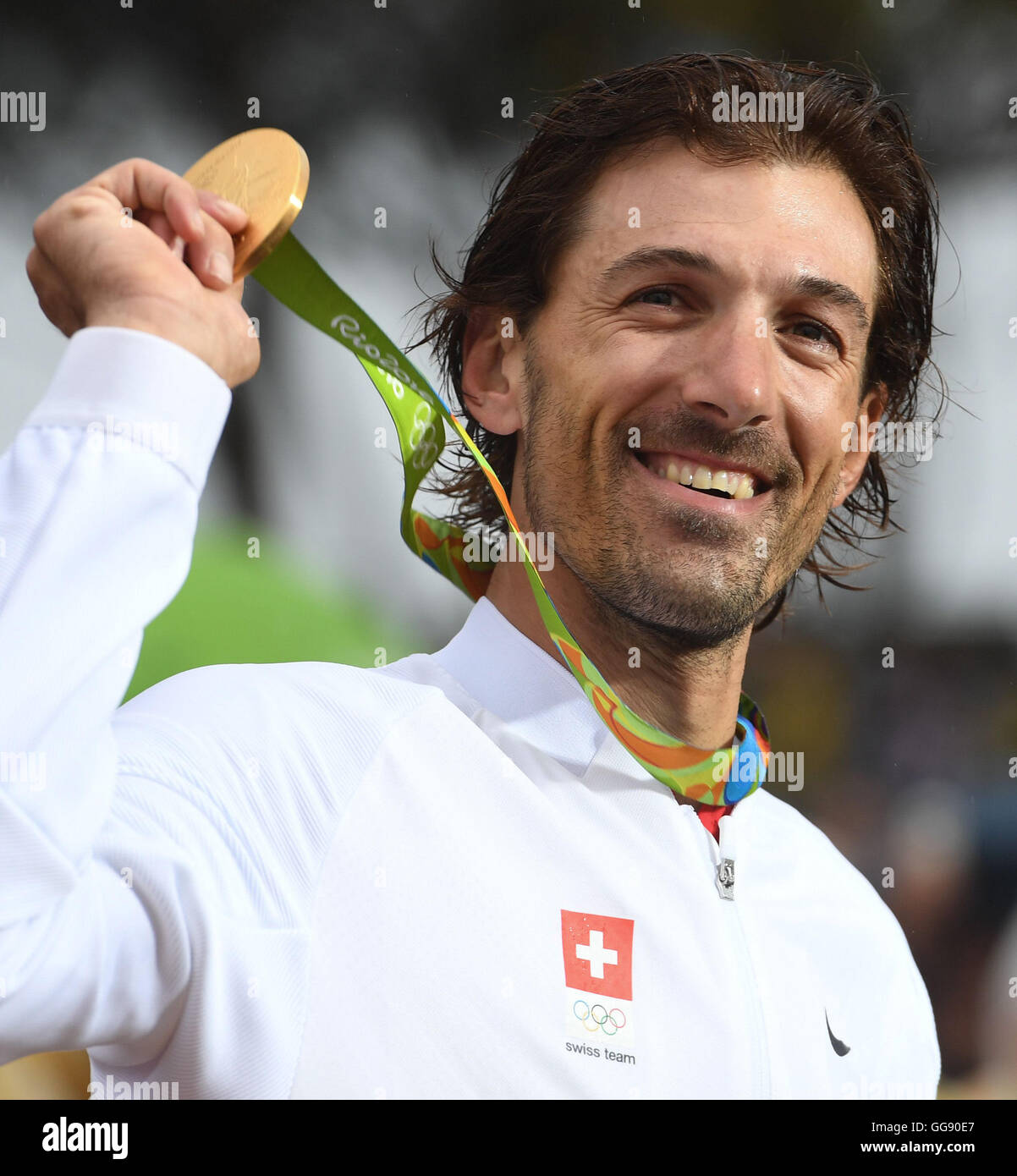 Rio de Janeiro, Brazil. 10th Aug, 2016. Fabian Cancellara of Switzerland celebrates on the podium with the gold medal after winning the men's Individual Time Trial of the Rio 2016 Olympic Games Road Cycling events at Pontal in Rio de Janeiro, Brazil, 10 August 2016.Photo: Sebastian Kahnert/dpa/Alamy Live News Stock Photo