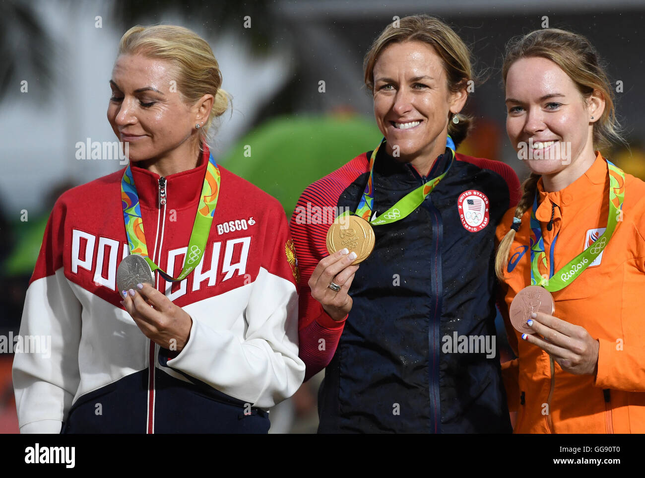 Rio de Janeiro, Brazil. 10th Aug, 2016. Kristin Armstrong (C) of the USA poses with her gold medal on the podium after winning the women's Individual Time Trial of the Rio 2016 Olympic Games Road Cycling events at Pontal in Rio de Janeiro, Brazil, 10 August 2016. Armstrong won ahead of second placed Olga Zabelinskaya (L) of Russia and third placed Anna van der Breggen (R) of the Netherlands. Photo: Soeren Stache/dpa/Alamy Live News Stock Photo