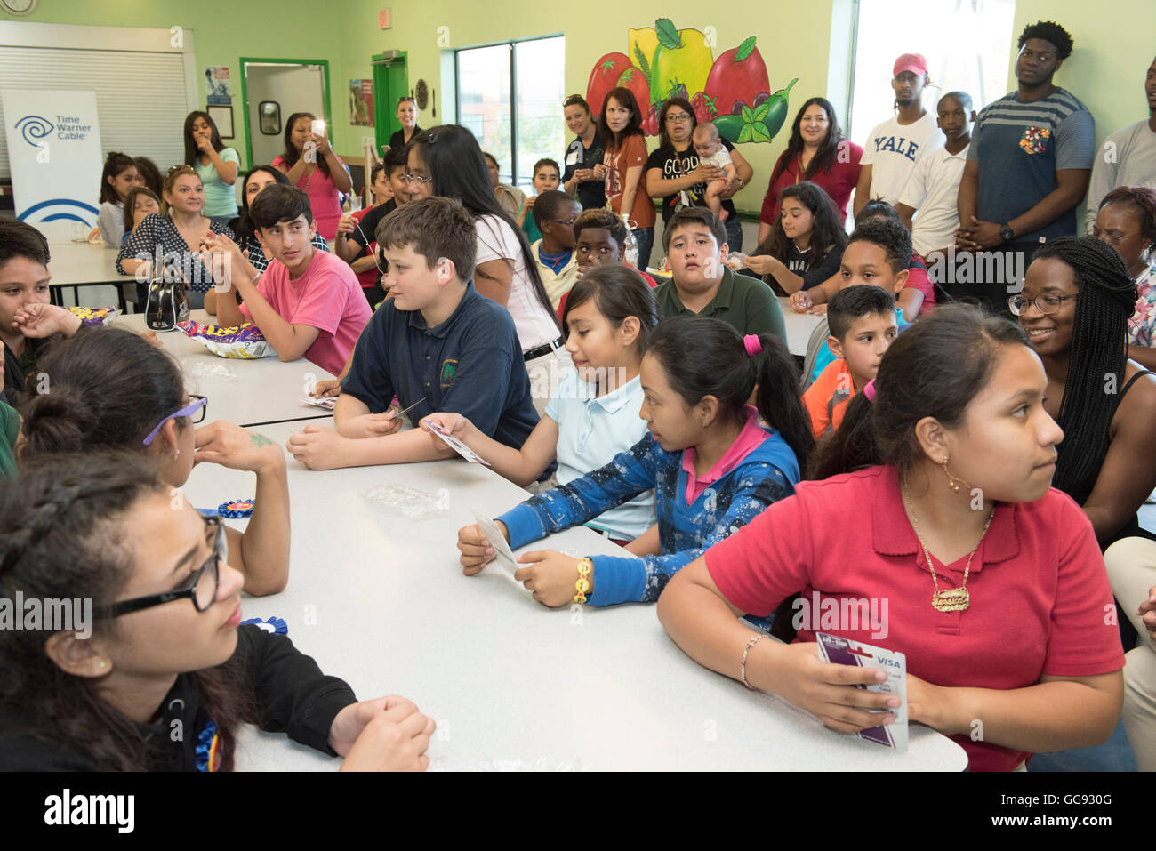 Multi-ethnic group of junior high students congregate in school cafeteria during after-school Earth Day program Stock Photo
