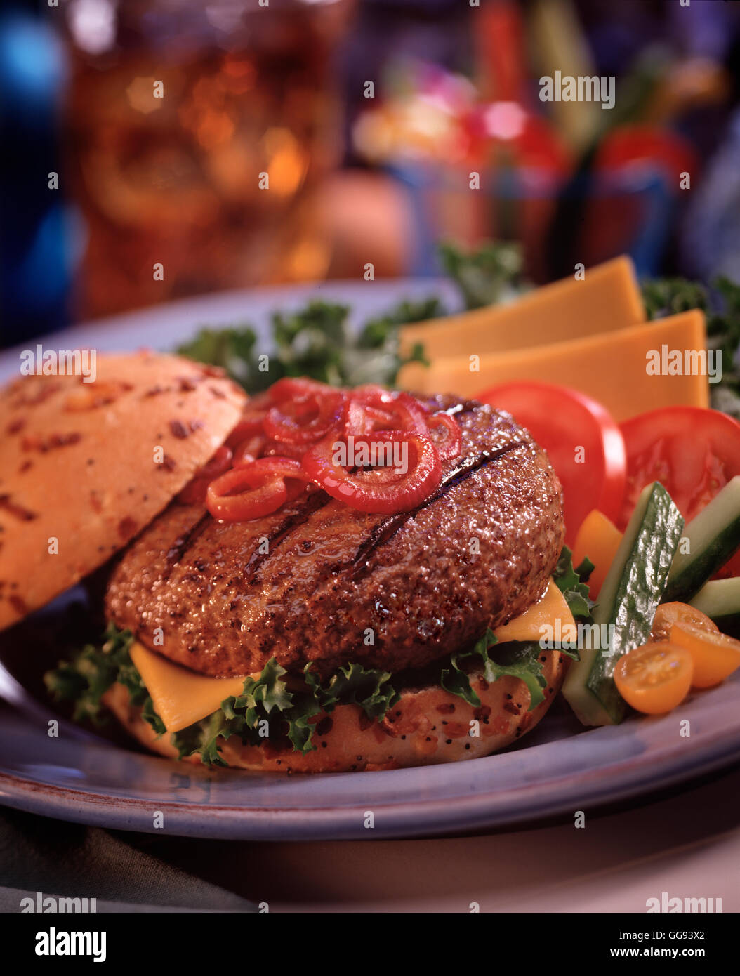 Summer Hamburger with sides toppped with grilled onions. Stock Photo