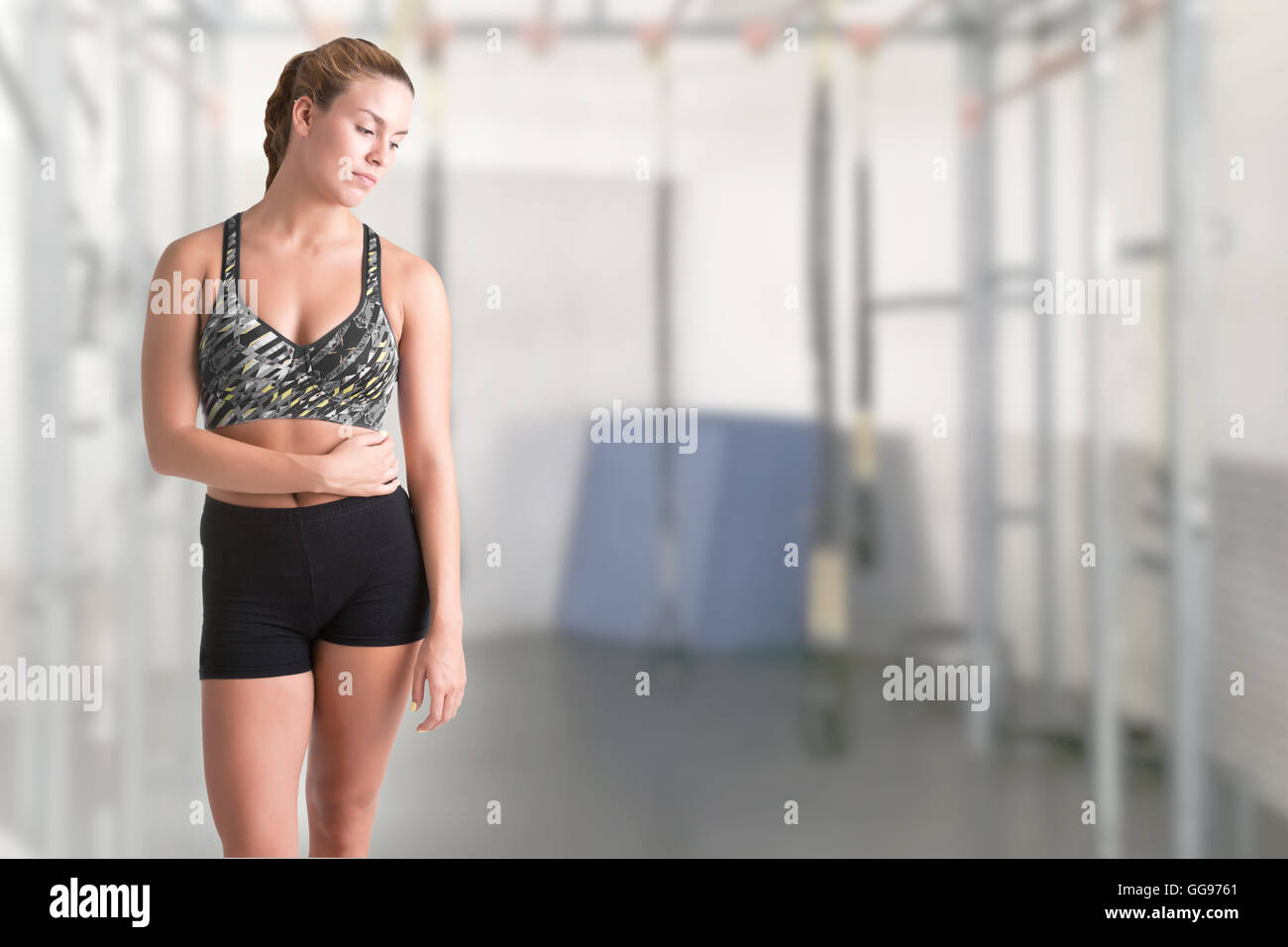 Fit woman standing and relaxing after a workout, in a gym Stock Photo