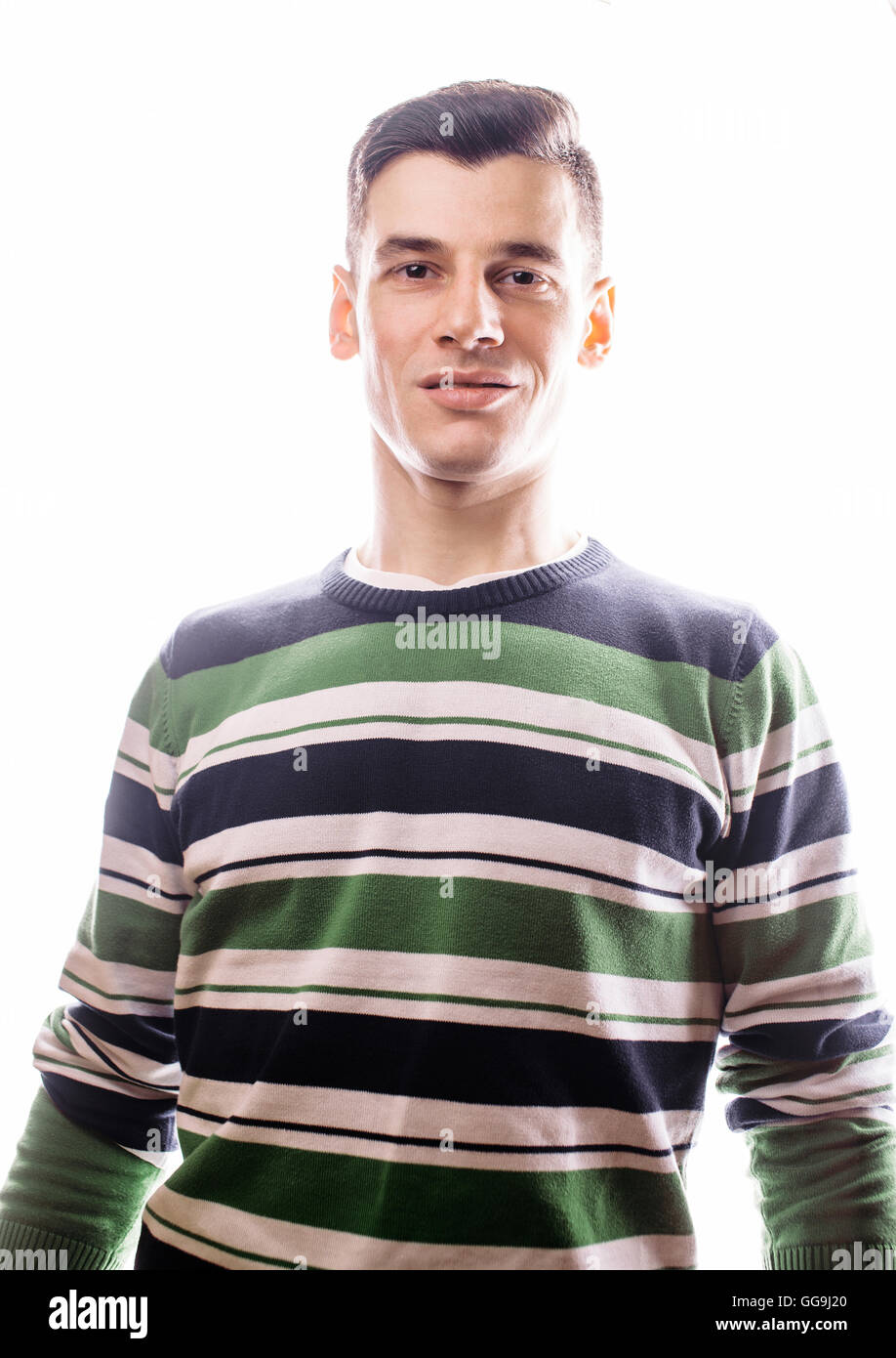 Portrait of a smart serious young man standing against white background ...