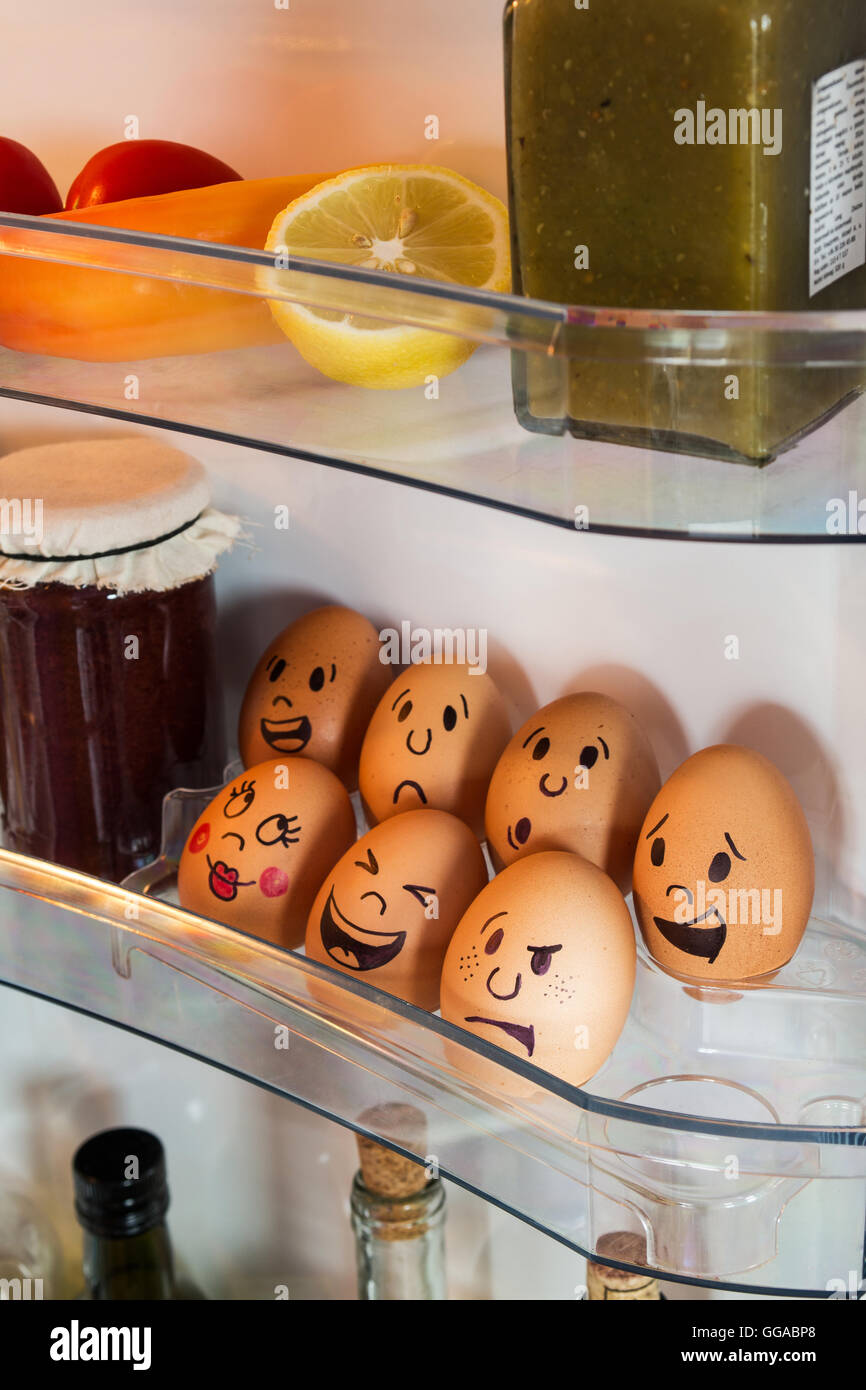 Funny egg faces in a fridge door. Stock Photo