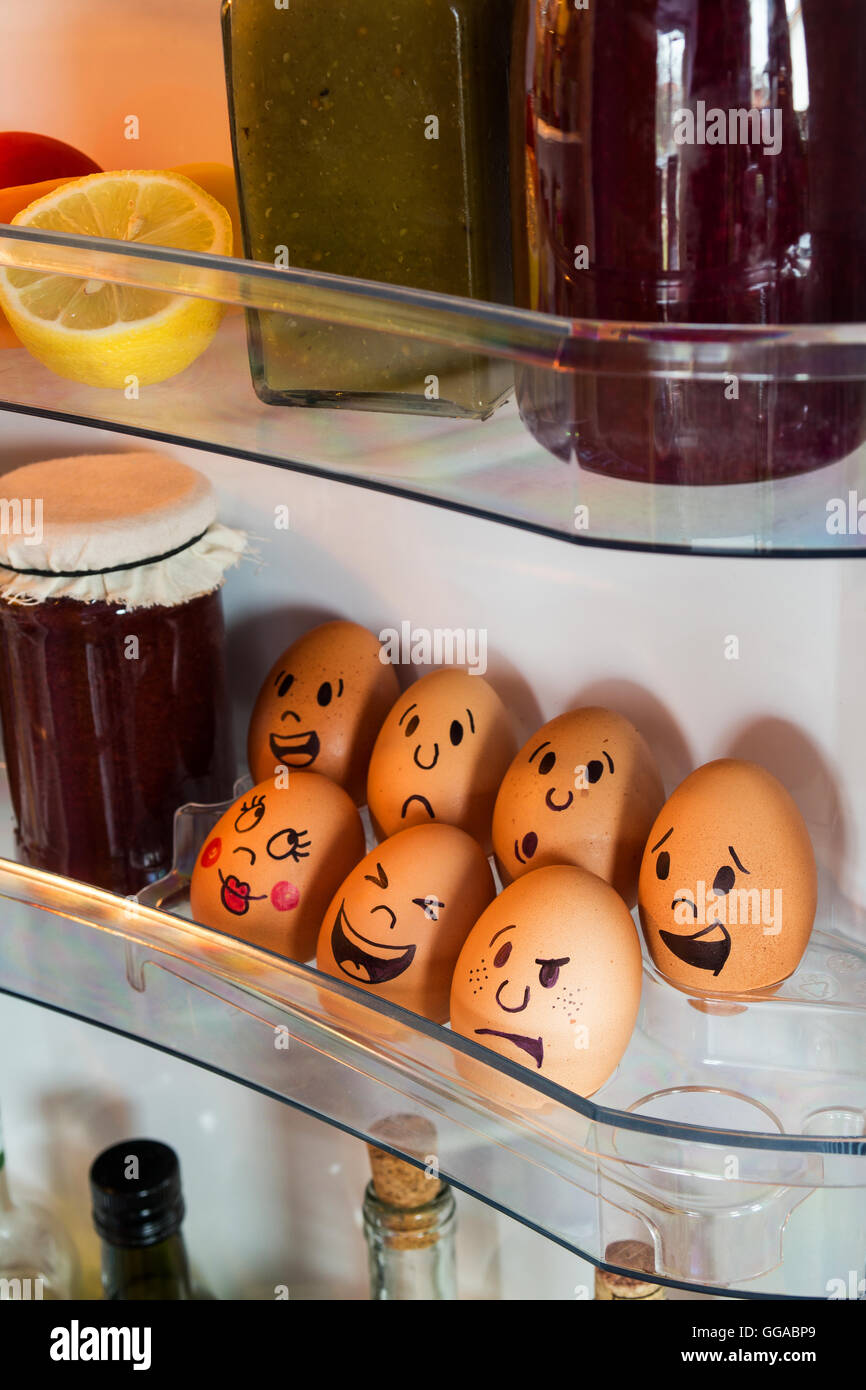 Funny egg faces in a fridge door. Stock Photo