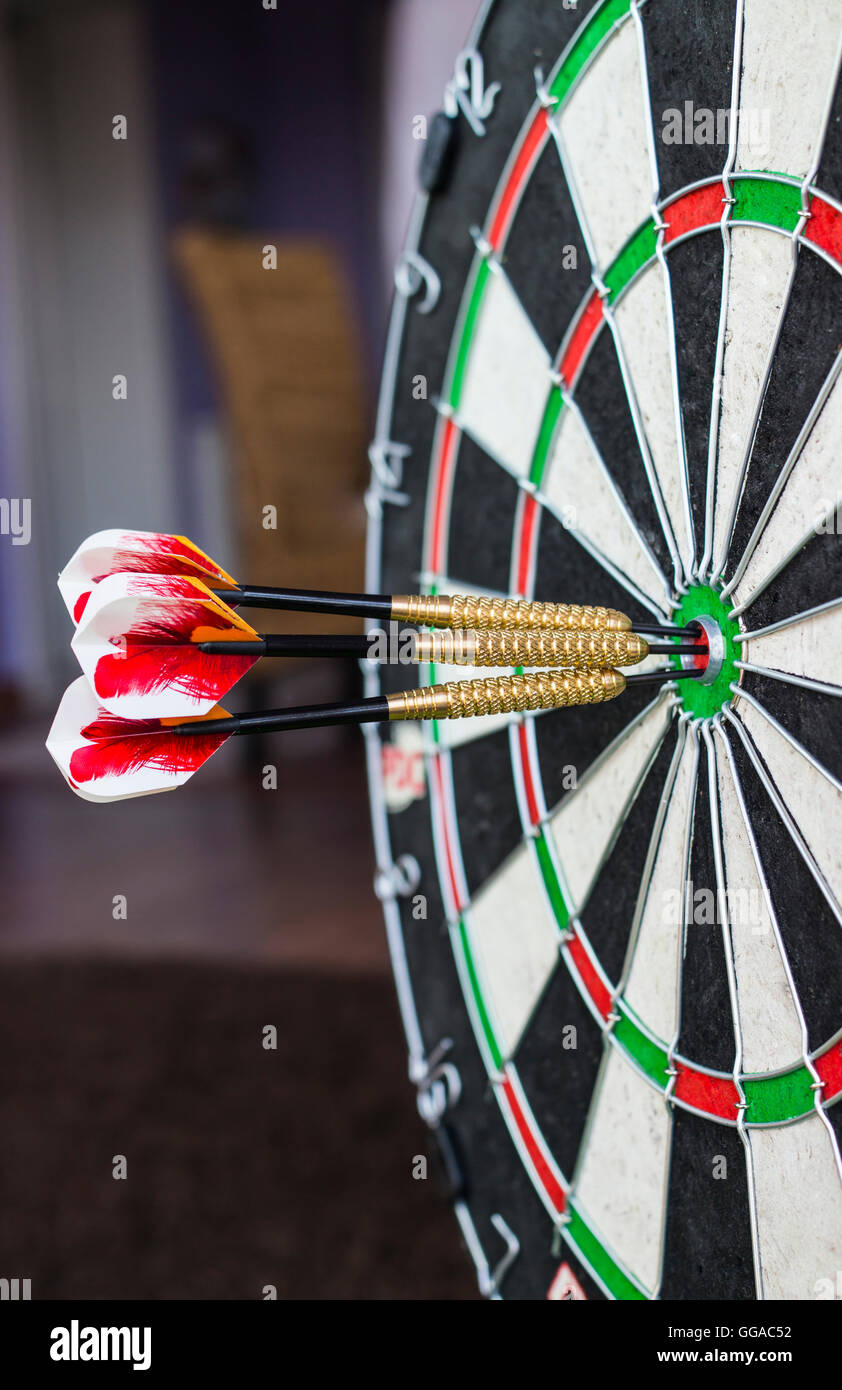 A dartboard closeup with three bullseye hits Stock Photo Alamy