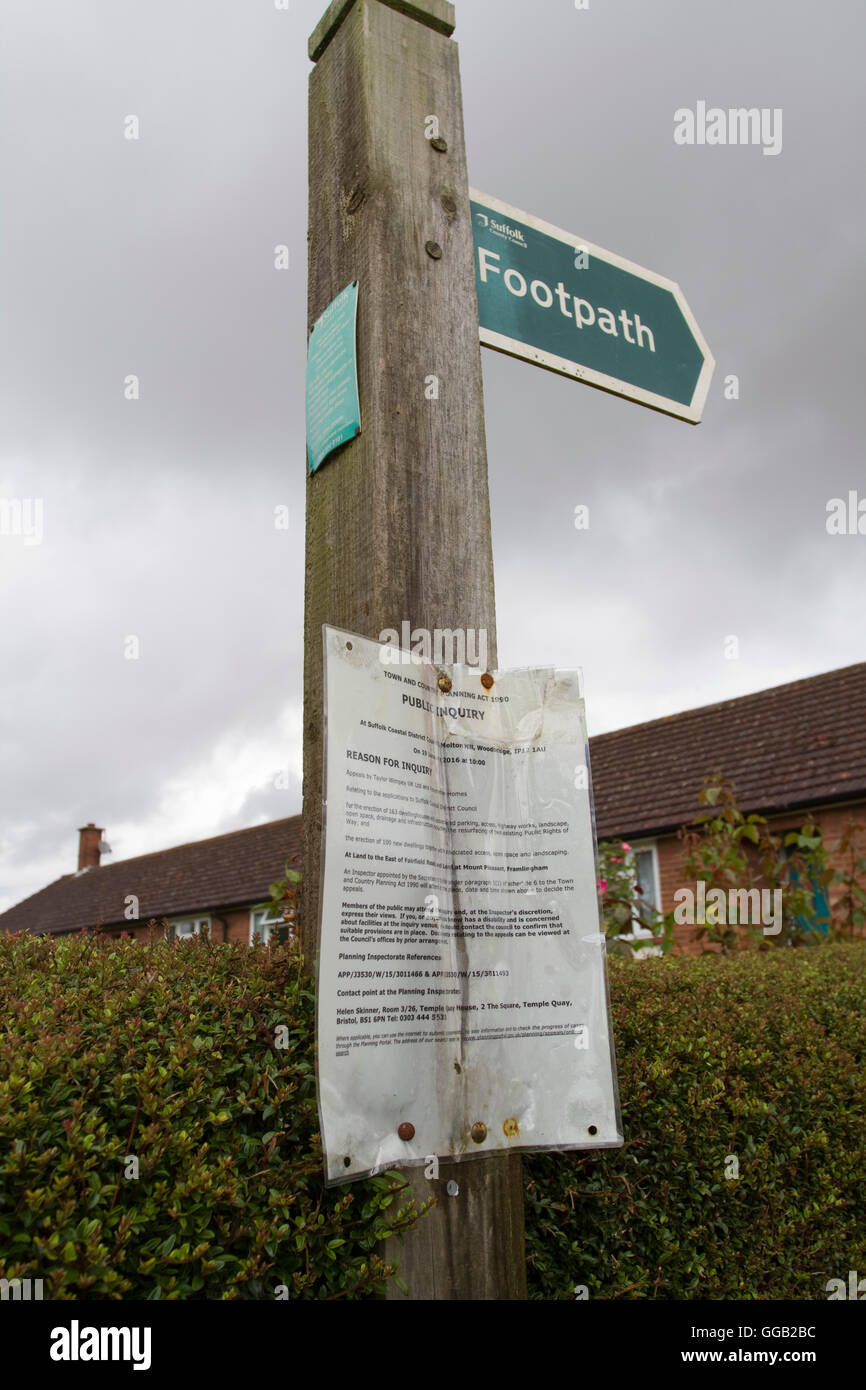 On a wooden footpath sign a planning Public Inquiry notice Stock Photo