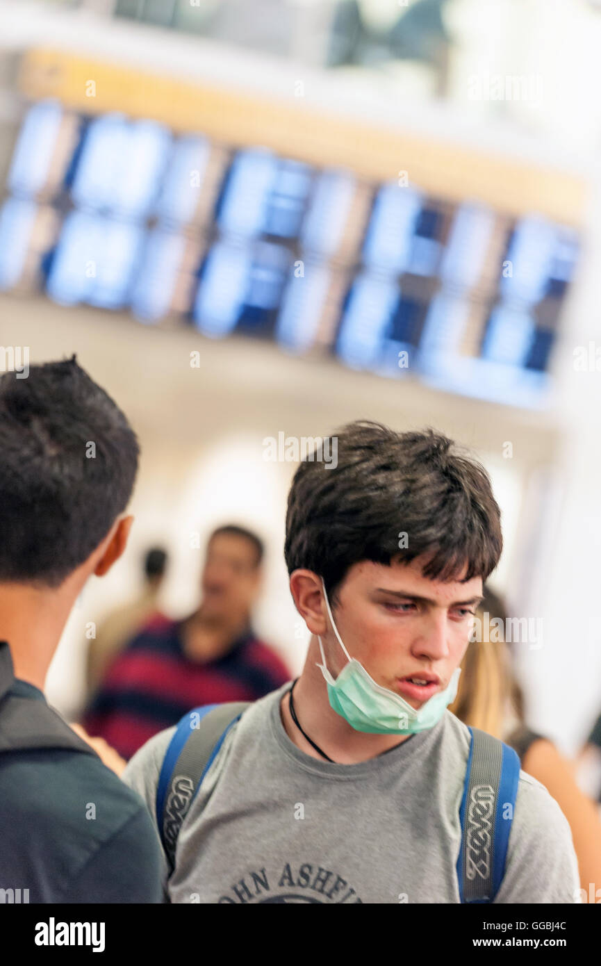 Passengers arriving on a plane from Italy wear facemasks to protect