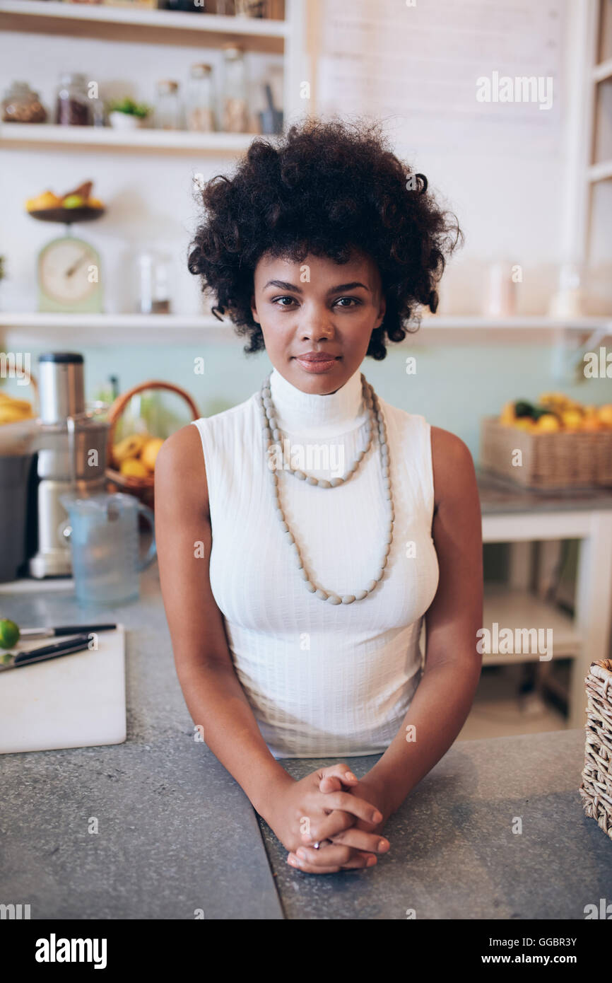 Portrait of confident young woman standing counter. African female juice bar owner looking at camera. Stock Photo