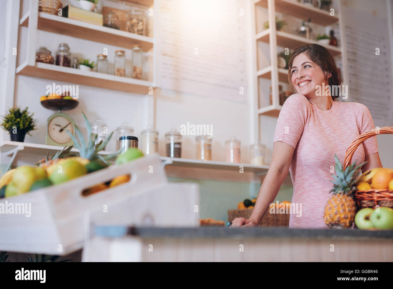 Portrait of beautiful young woman standing behind the counter of her juice bar. Caucasian female working at a juice bar looking Stock Photo