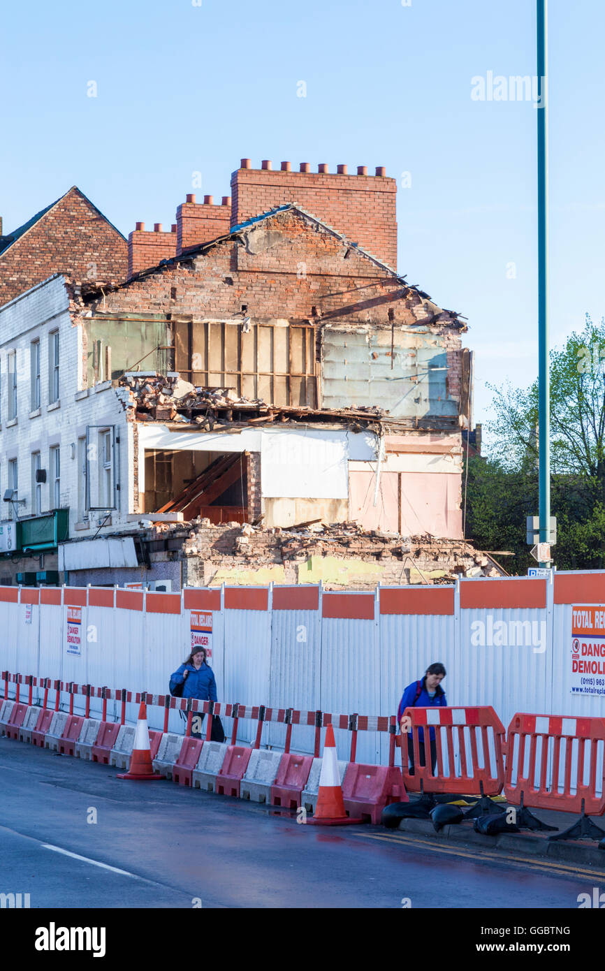 Building demolition work. People walking past fenced off buildings being demolished, Nottingham, England, UK Stock Photo