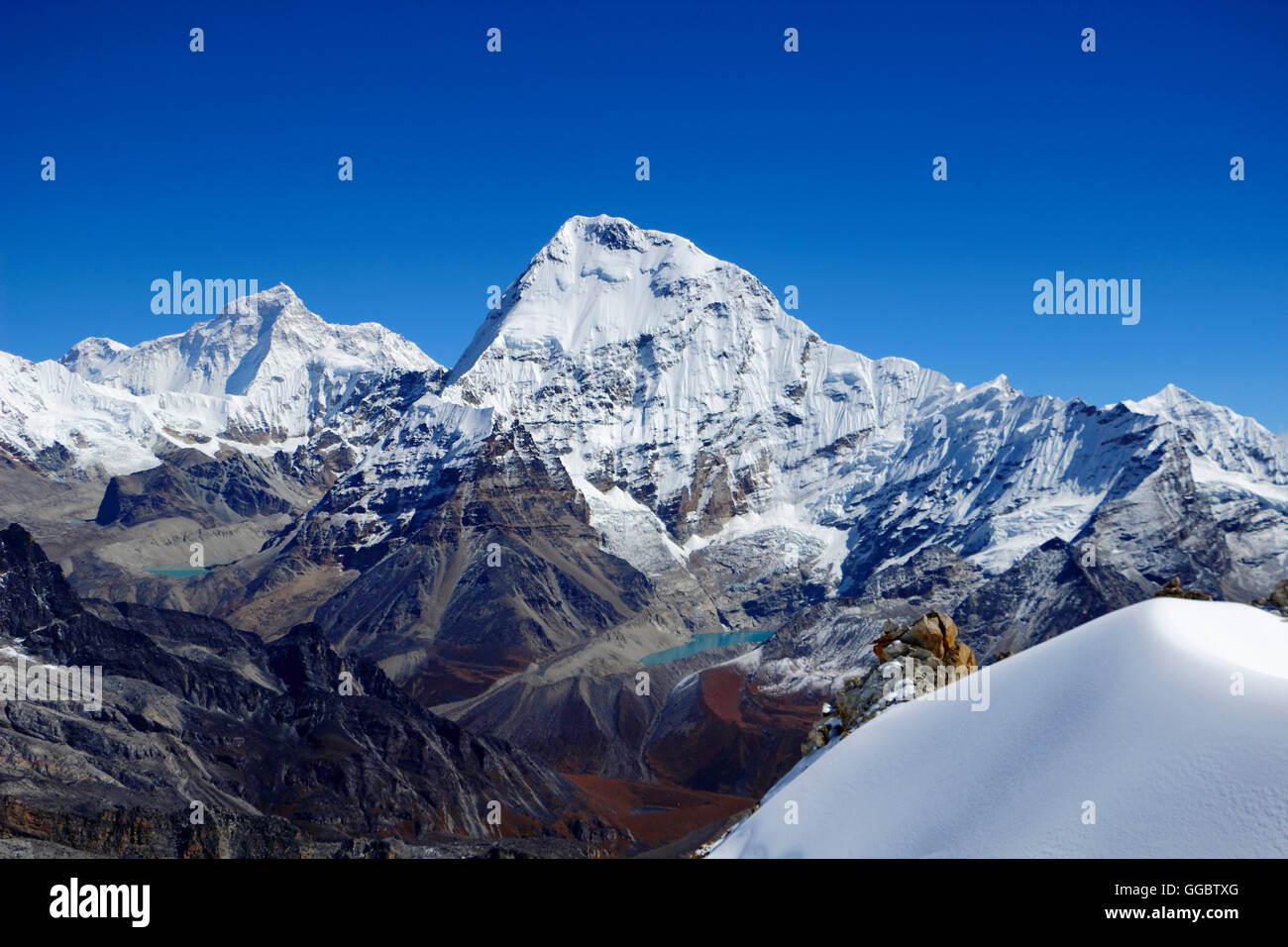 Snow covered fields fall away to valley - Mera la and Kyasar mountain Stock Photo
