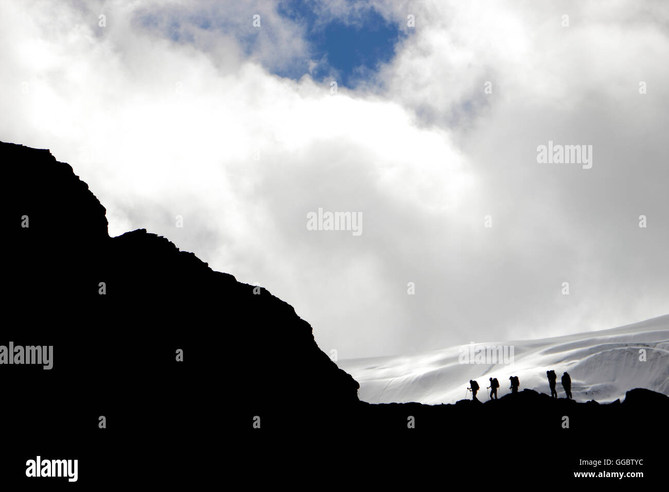 Climbers silhouetted on route dwarfed by snow fields and glacier of Mera Peak Stock Photo