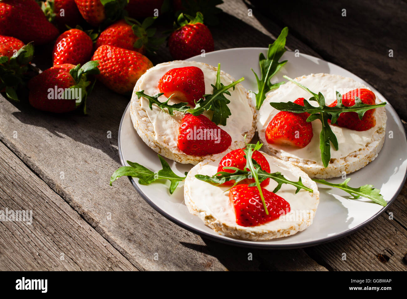Multigrain rice cakes with strawberries fruit , soft mascarpone cheese