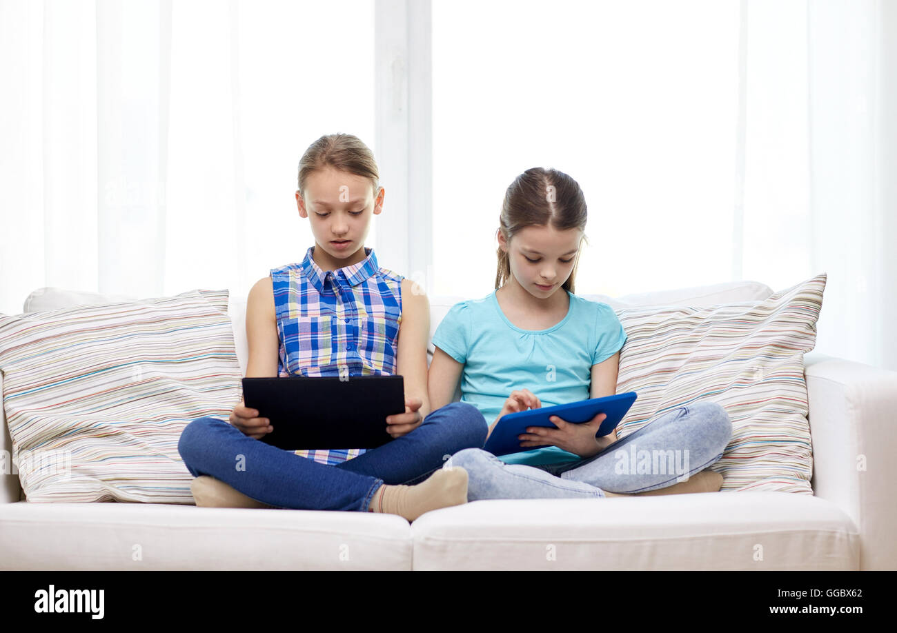 girls with tablet pc sitting on sofa at home Stock Photo - Alamy