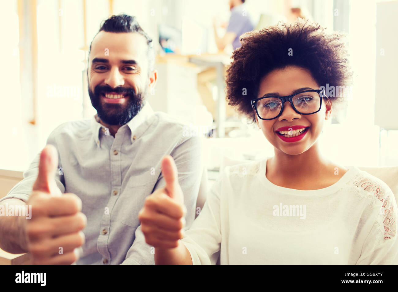 happy creative team in office showing thumbs up Stock Photo - Alamy