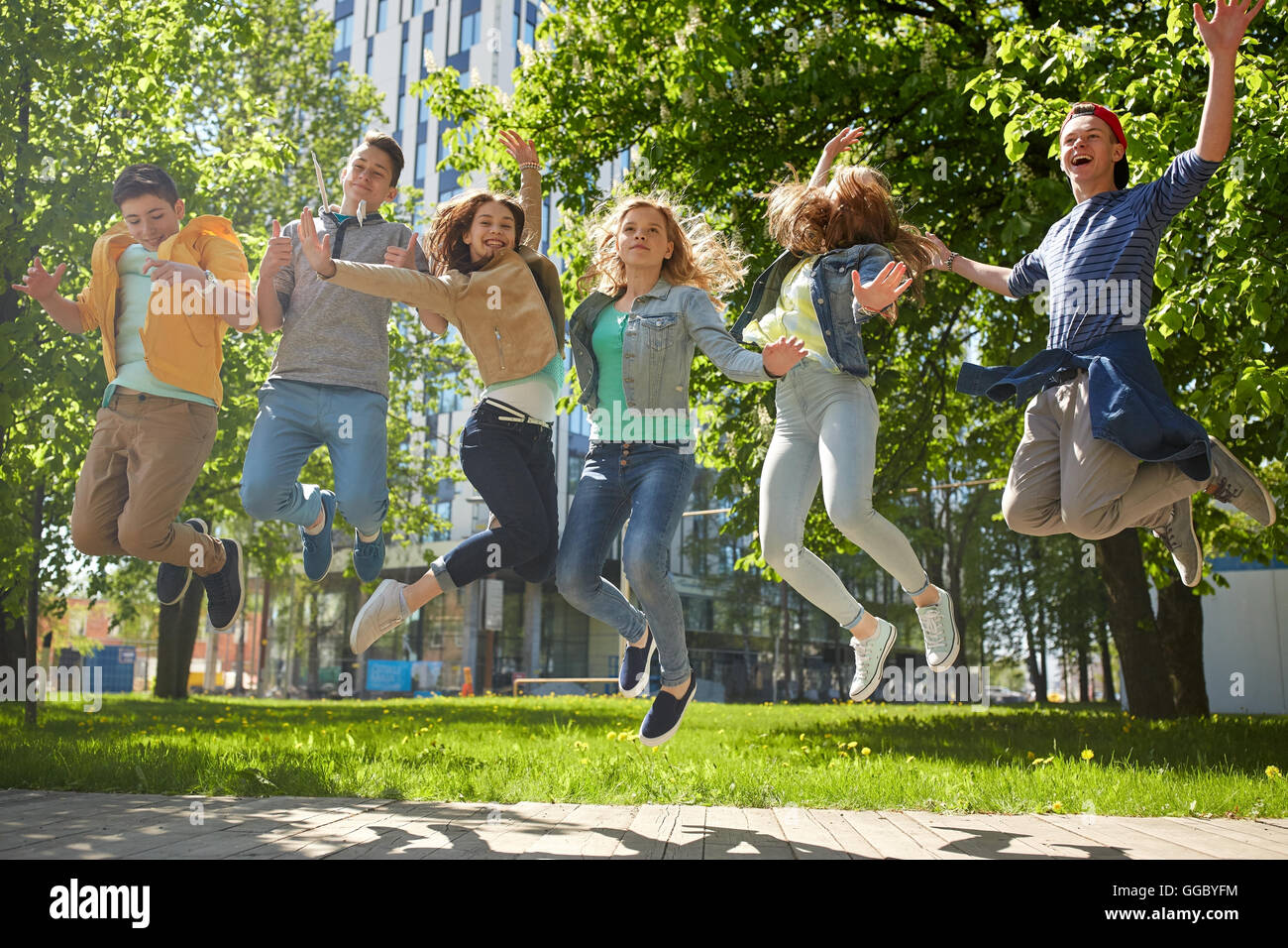 happy teenage students or friends jumping outdoors Stock Photo - Alamy