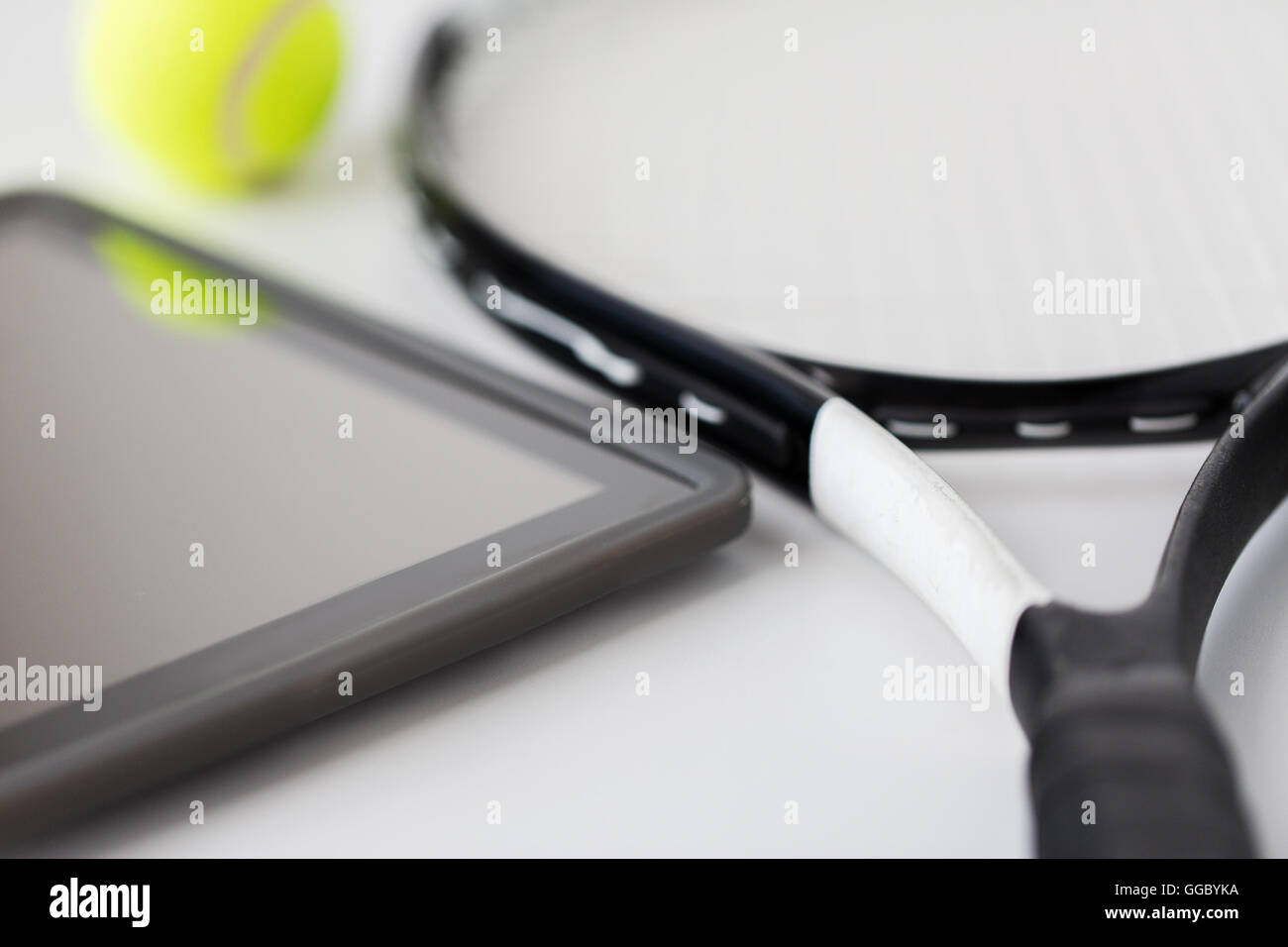 close up of tennis racket with ball and tablet pc Stock Photo
