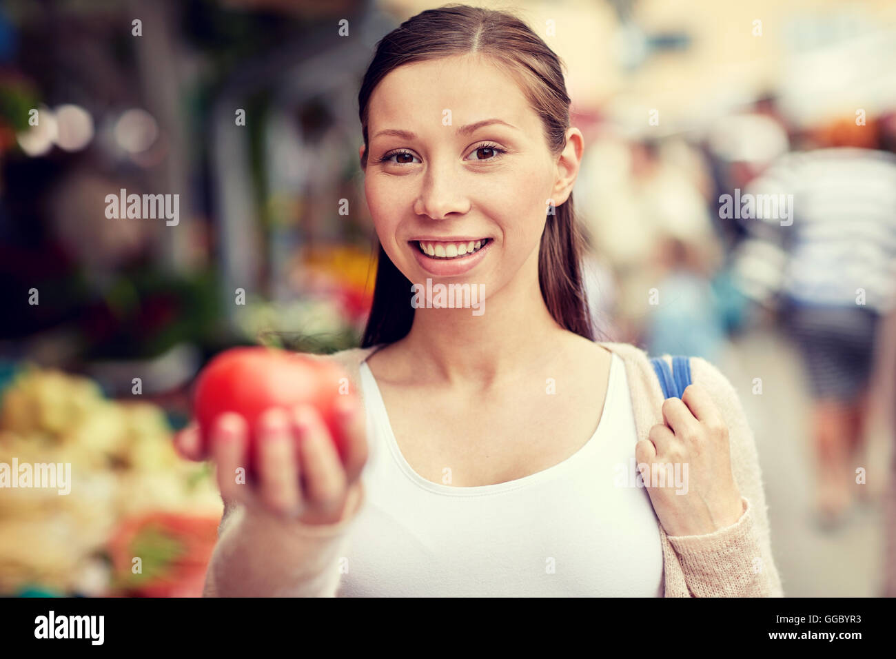 happy woman holding tomato at street market Stock Photo - Alamy