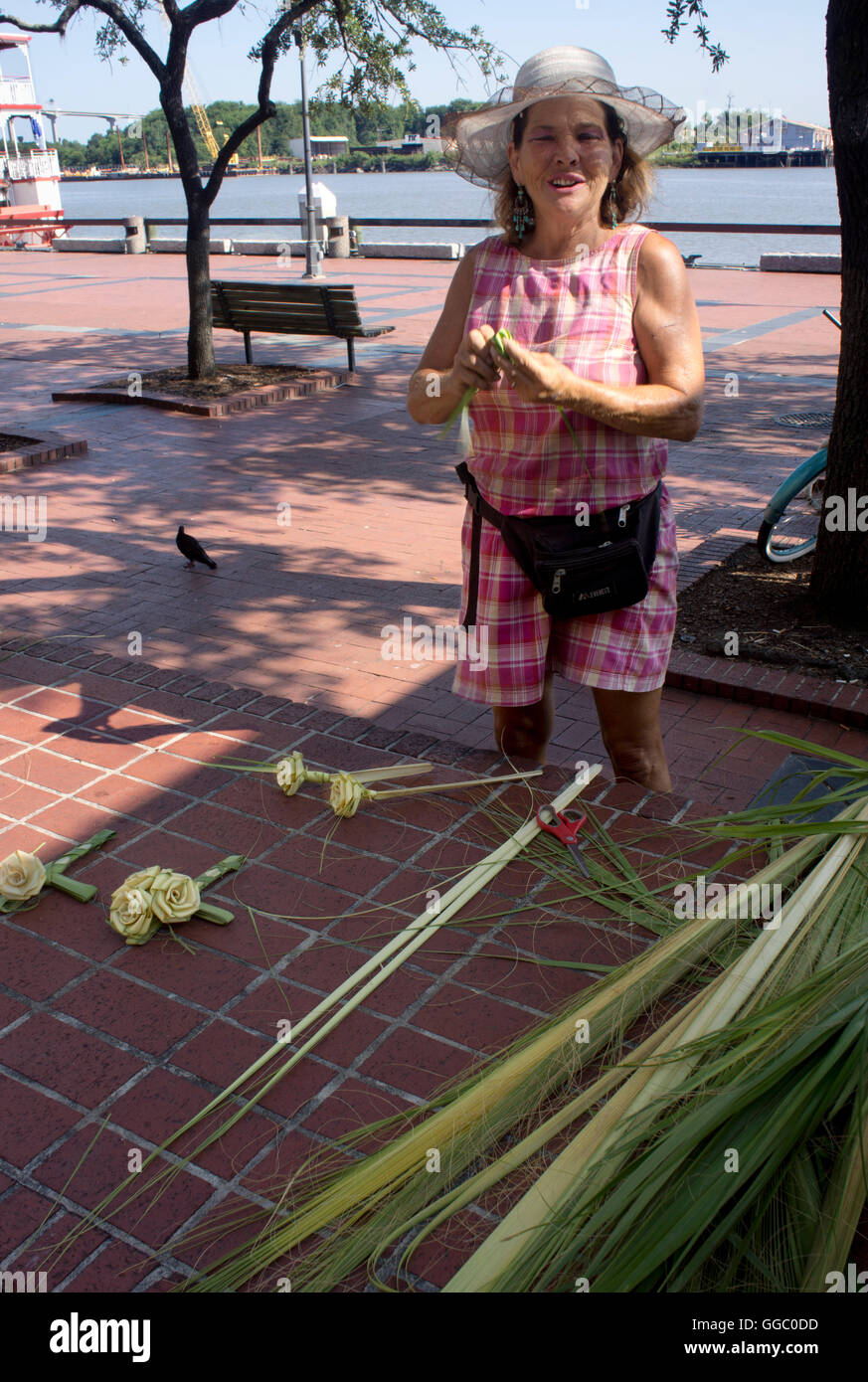 Savannah resident on the riverfront creating the Southern palm frond rose, a tradition & craft handed down by many generations. Stock Photo