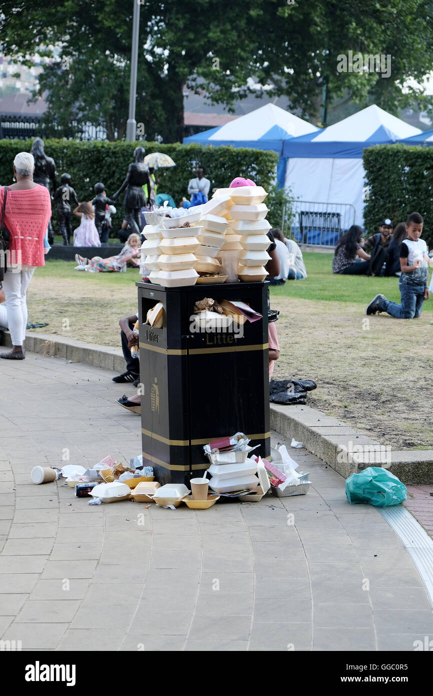 A street side public rubbish bin full to capacity and overflowing with fast food containers Stock Photo